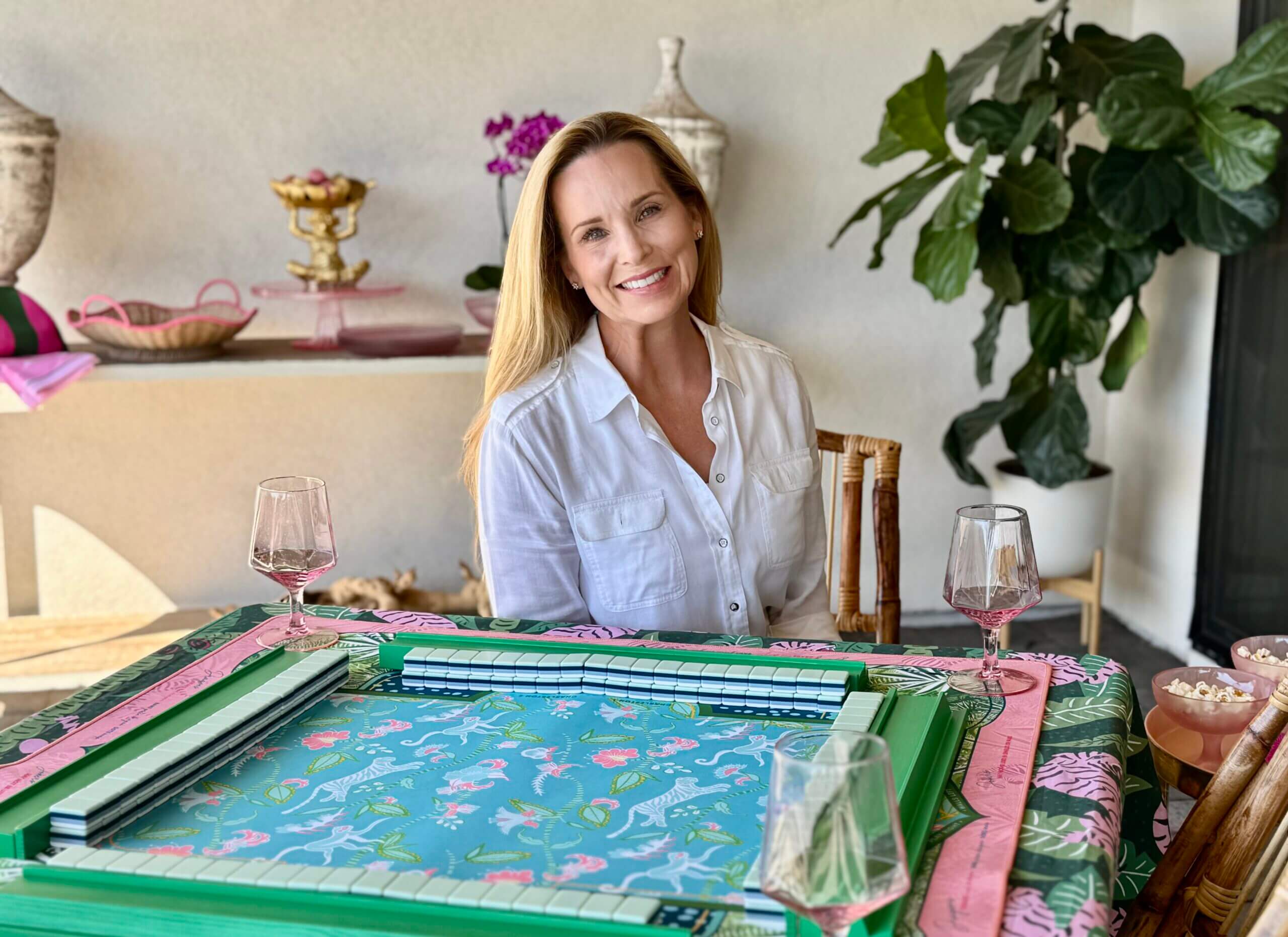 A woman smiling while playing mahjong indoors.
