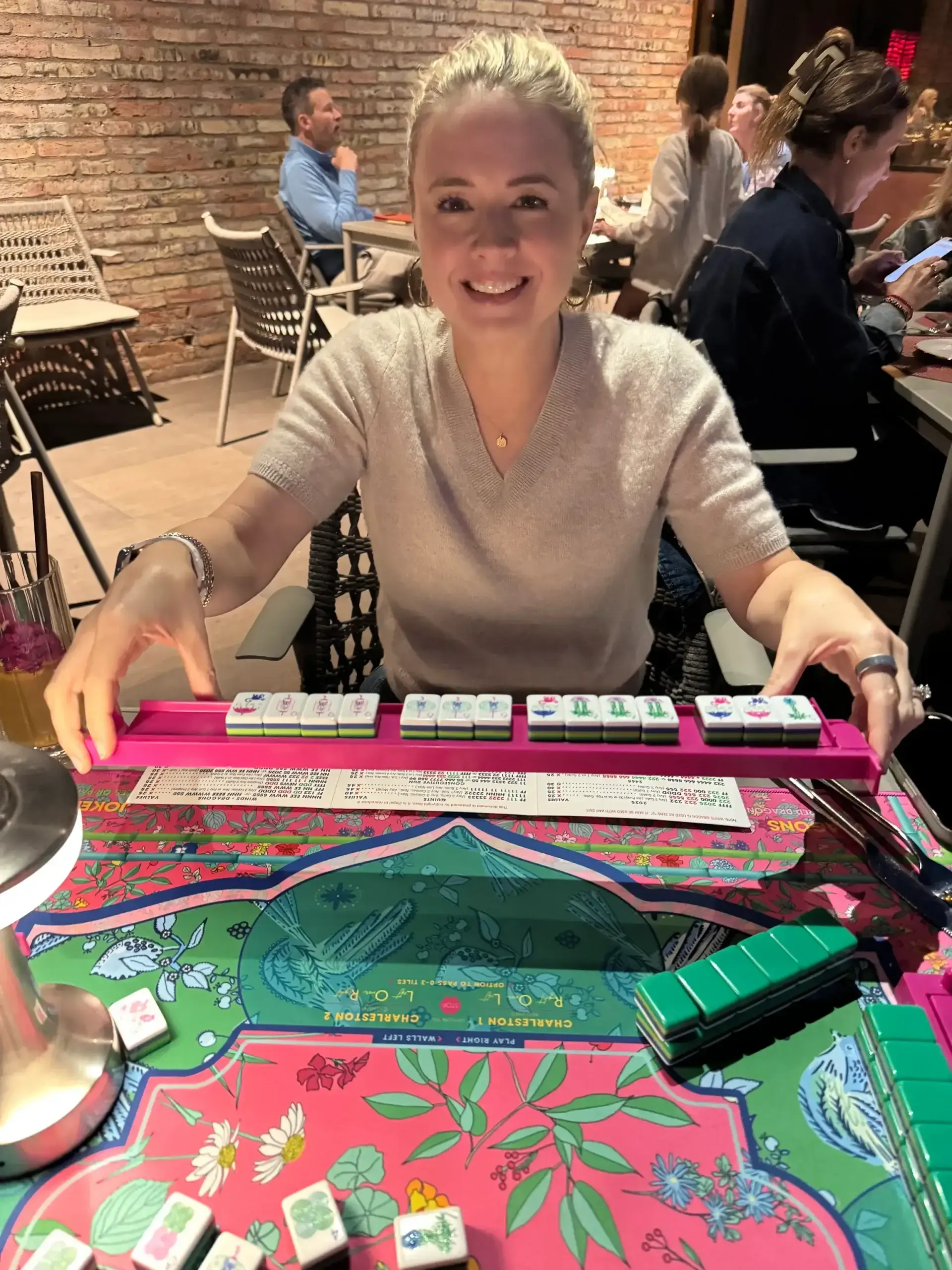 Smiling woman playing mahjong at colorful table